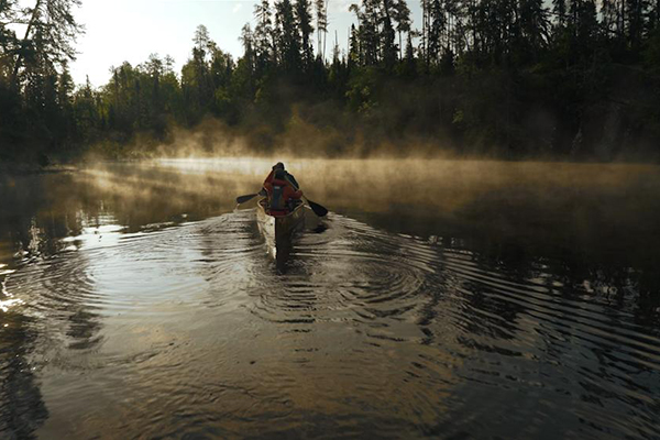 People in a conoe on a lake.